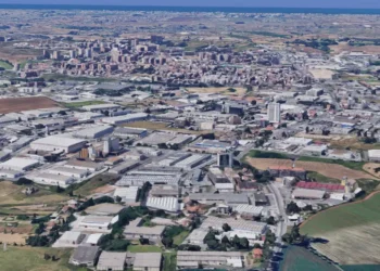 Pomezia, in primo piano capannoni dell'area industriale, sullo sfondo il centro della città