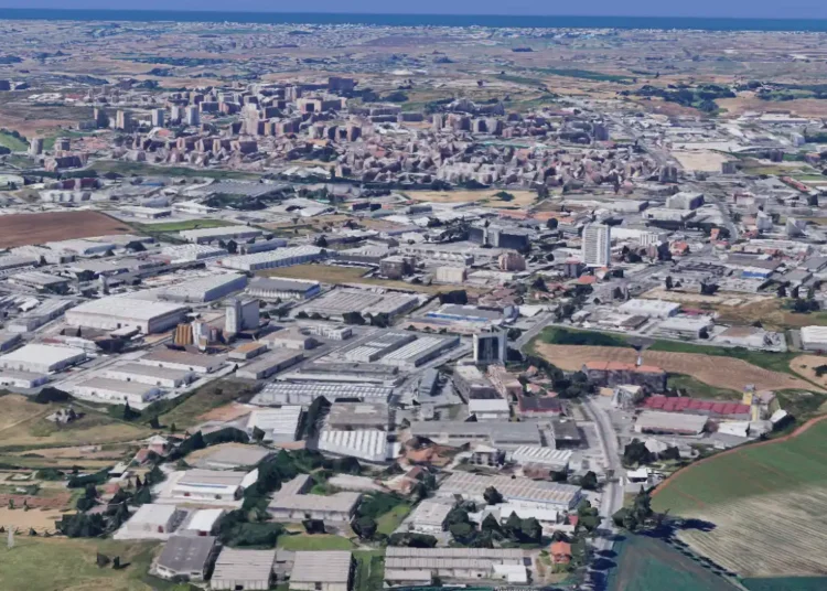 Pomezia, in primo piano capannoni dell'area industriale, sullo sfondo il centro della città