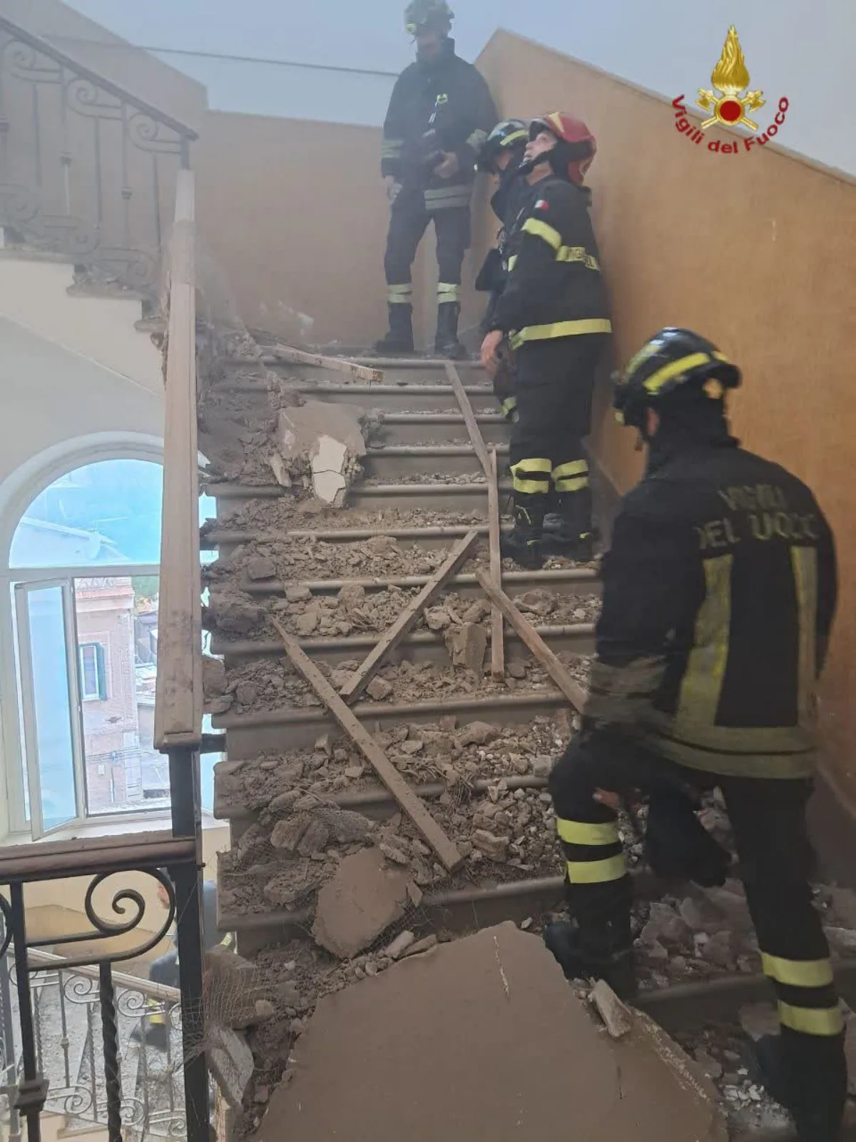 I Vigili del Fuoco sulle scale piene di calcinacci dopo il crollo del controsoffitto